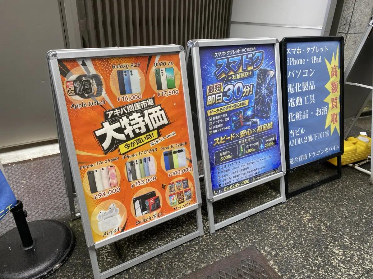 ドラゴンモバイル秋葉原本店の店頭看板(2026年7月2日撮影)。iPhone・パソコン等の高額買取の案内